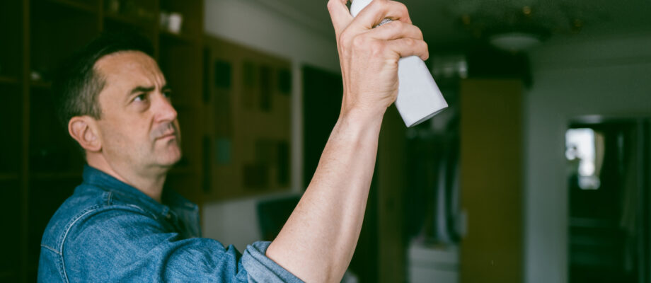 Man using mosquito repellant to keep mosquito away in summer